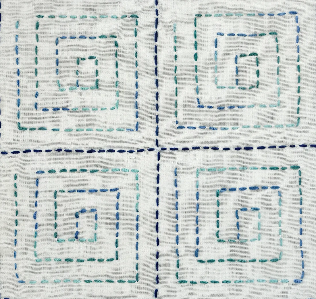 Raimon (lightning spiral) sashiko pattern hand-stitched in blue thread on natural linen