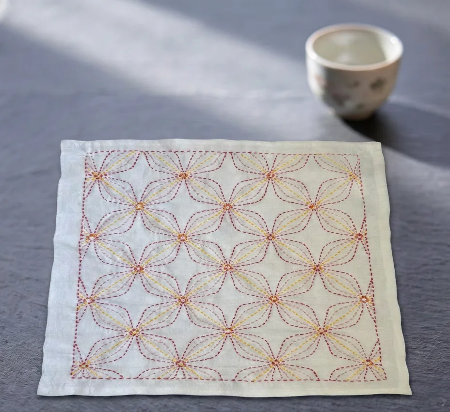 The finished Hanazashi hanafukin laid flat next to a teacup